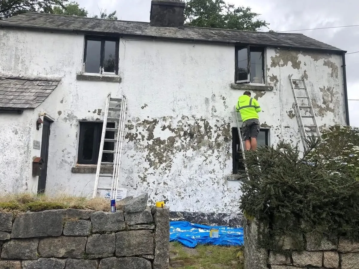 Cottage with blown, flaking render before repair in Torpoint